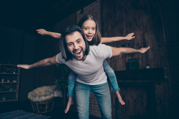 快乐照片中的小搞笑精力充沛的女孩兴奋帅气的爸爸抱着女儿玩游戏好心情消磨空闲时间手飞行爸爸