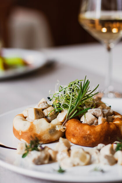 香菇塞满奶酪的蘑菇 蘑菇茎和微绿放在白盘子上 在餐厅里喝一杯葡萄酒填充健康餐厅