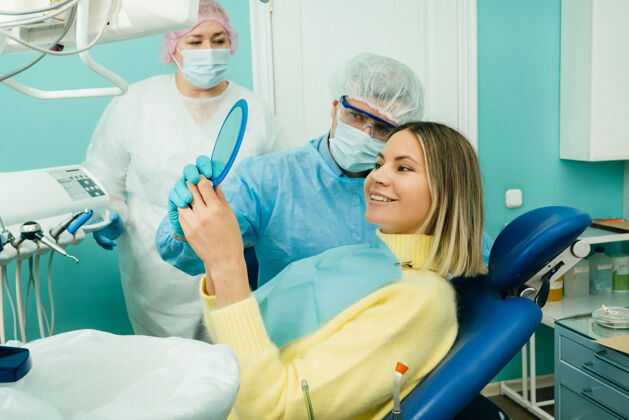 表演牙医在镜子里给病人看他的工作结果手治疗办公室