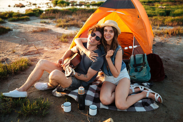 旅游快乐的年轻夫妇在湖边露营冒险关系太阳镜