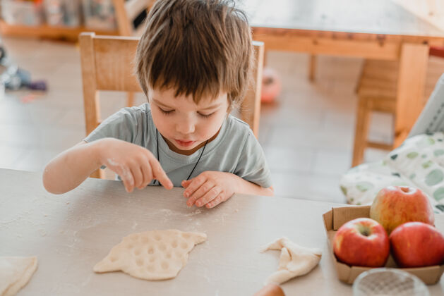 糕点可爱的小男孩在厨房准备面团做糕点可爱面包厨师