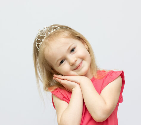 肖像一个戴着皇冠 穿着粉色裙子 带着可爱笑容的年轻女孩白色梦想女孩