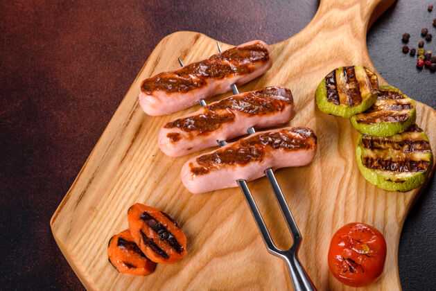 猪肉新鲜美味的香肠 用蔬菜和香料烤制而成药草.照片在一张深色的水泥桌子上的盘子餐厅晚餐野餐