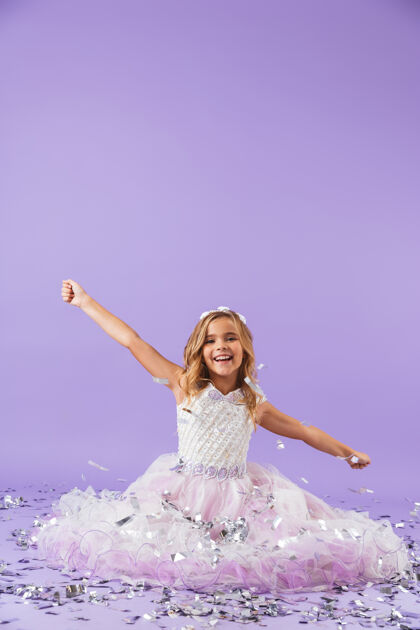束穿着公主裙的漂亮小女孩孤零零地坐在紫罗兰色的墙上吸引力连衣裙美丽