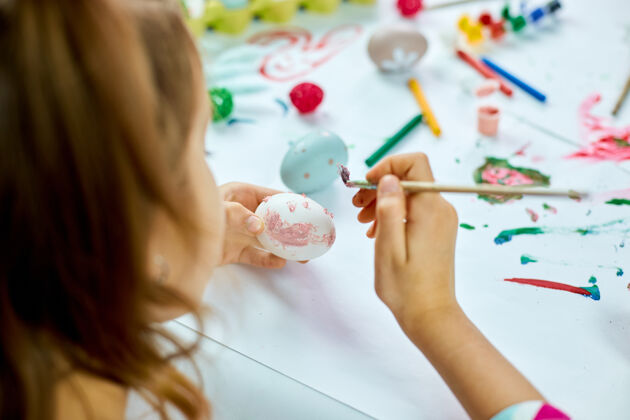 油漆认不出来的小女孩在家画画 用毛笔蛋画画孩子准备复活节 玩得开心 庆祝节日复活节快乐 diy厨房食物小女孩