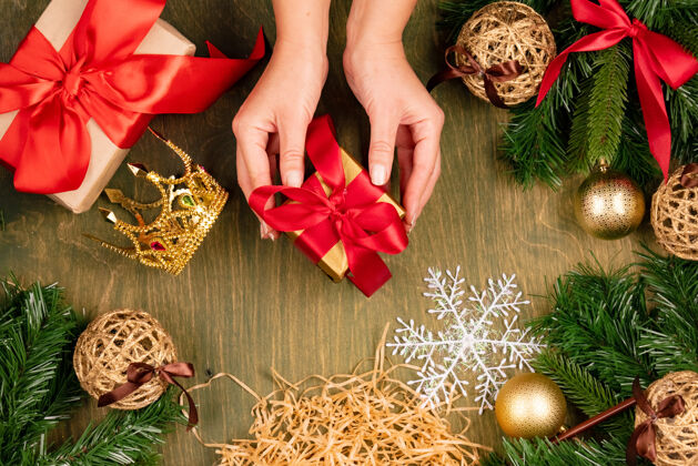 球绿色木质纹理背景上的圣诞装饰 顶视图 设计的自由空间 手中的礼物躺着庆典活动