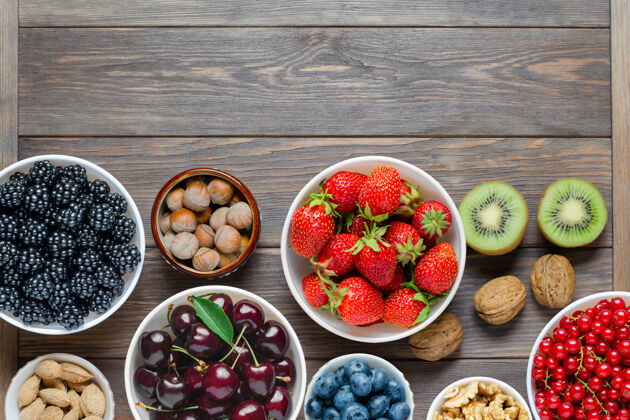 浆果新鲜浆果 坚果和水果的混合物健康食品含有大量的维生素和有益的微量元素元素棕色木质背景复制空间抗氧化剂观点水果