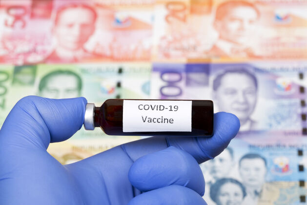 玻璃以菲律宾比索为背景的covid-19疫苗冠状病毒大流行针头