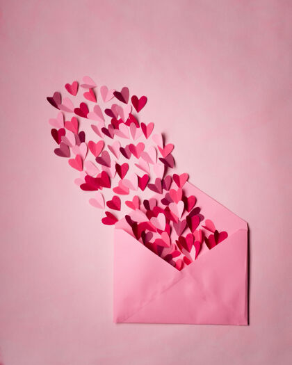 信红色和粉红色的纸心在打开的粉红色信封上颜色心打开
