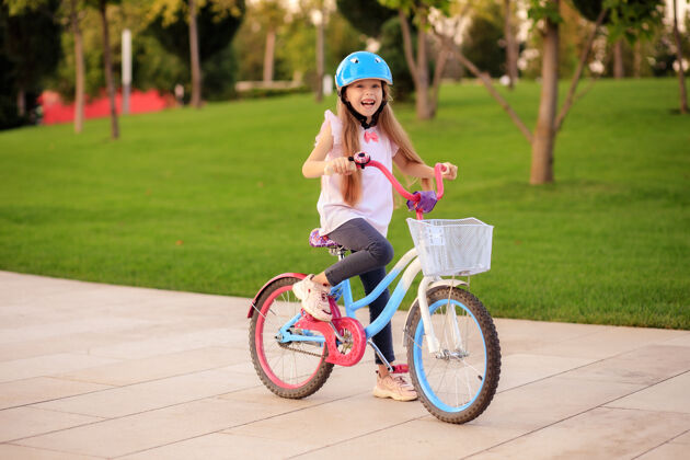运动快乐快乐的小女孩在公园里骑自行车小小夏天