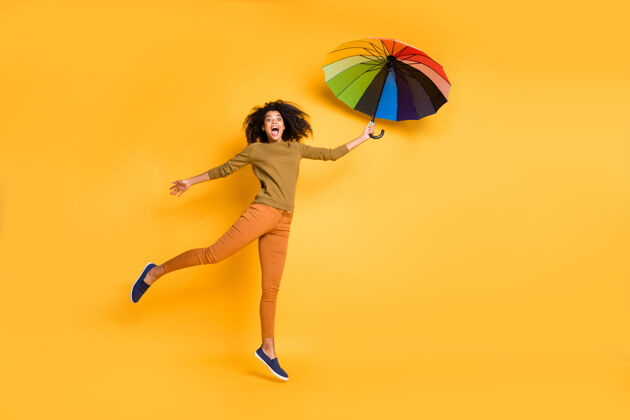 皮肤全身尺寸的照片波浪欢快可爱可爱漂亮漂亮的女朋友带伞飞行穿着橙色裤子鞋子隔离在生动的黄色背景天气非洲向上