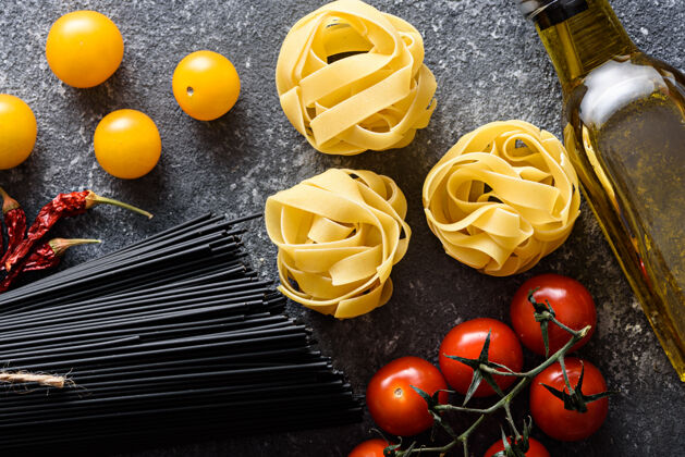 西红柿俯瞰意大利晚餐的意大利面 黑色意大利面 意大利面 西红柿 橄榄油灰底 烹饪理念饮食新鲜面食烹饪