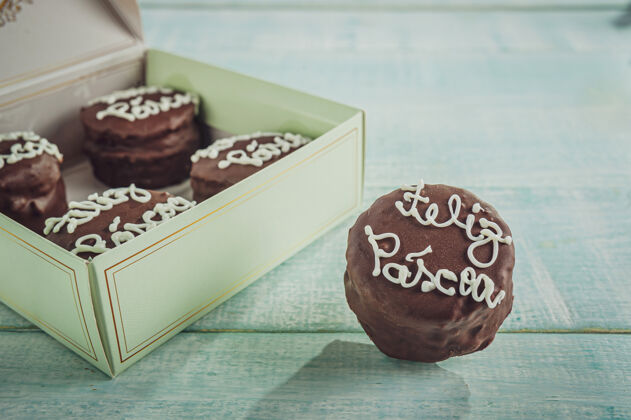 糖果蜂蜜曲奇巧克力覆盖着一个礼品盒写着复活节快乐-保德梅尔Alfajores食物桌子