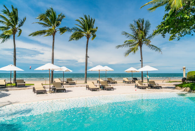 海洋海滨度假酒店游泳池周围的沙滩椅海滩.假日还有度假的概念无限游泳旅游