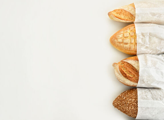 面包房不同类型的面包在白色的纸袋上背景.top查看烘焙面包各种
