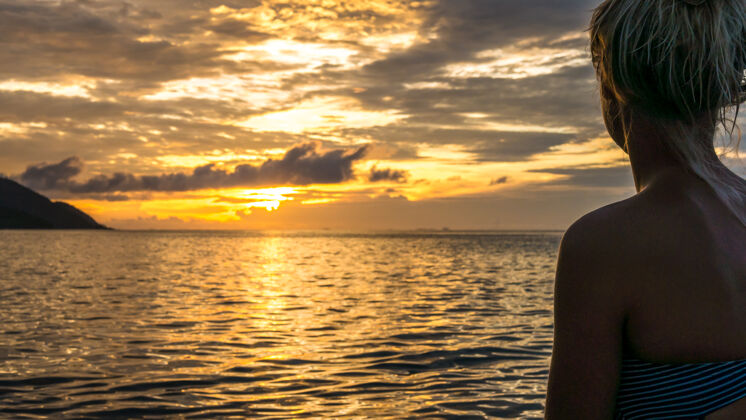 小屋在温暖的夕阳下的少女剪影 克里米亚拉贾岛安帕特 印度尼西亚 西巴布亚水岛屿天堂