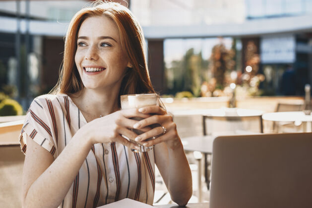 自由职业者一个可爱的年轻女学生在咖啡店喝咖啡和微笑的肖像连接休闲午餐时间