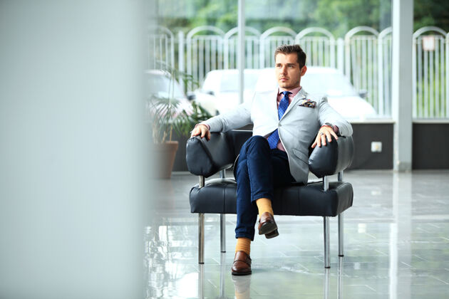 办公室低角度拍摄一个英俊的年轻商人在一个时尚的现代办公空间创业精神坐着的通信