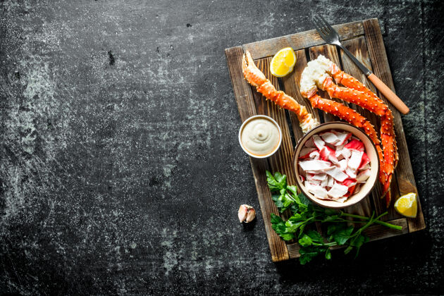 海蟹肉和新鲜的螃蟹放在一个木制托盘上 上面放着柠檬片 酱汁和香草营养鱼开胃菜