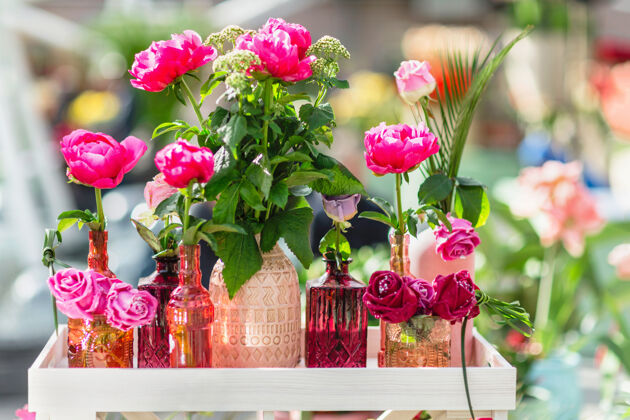 桌子新鲜和装饰不同花瓶的人造玫瑰花瓣美丽假