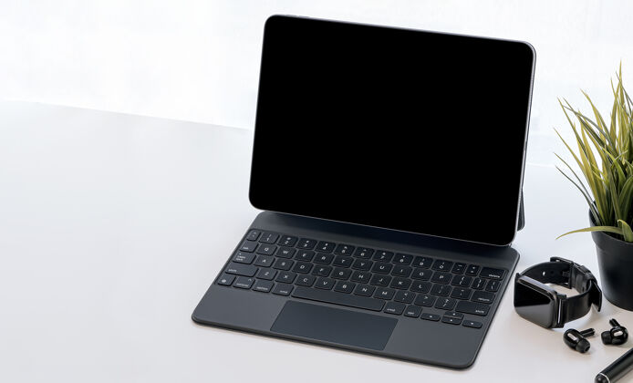 桌子模拟黑屏平板电脑与魔术键盘 智能手表和耳机的白色桌面桌上室内键盘智能手表