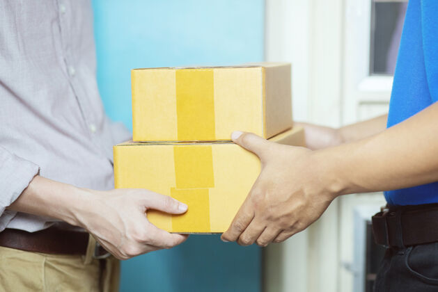 纸箱包裹投递员通过一个包裹投递服务人职业交付