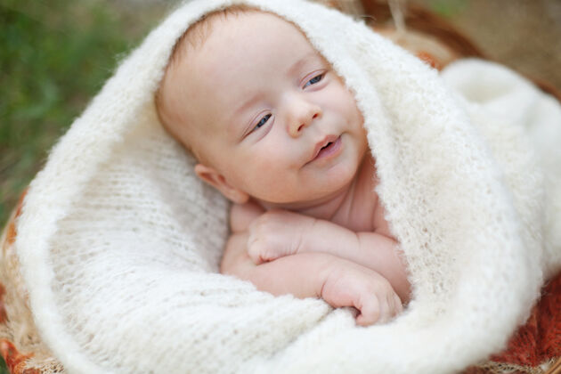 反射一个两个月大的小婴儿趴在地上 头上裹着柔软的白色绒毛毯子高高质量的照片清洁男孩孩子