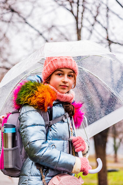 肖像金发碧眼的女孩穿着夹克带着透明的雨伞在外面的雨中御寒外套户外天气