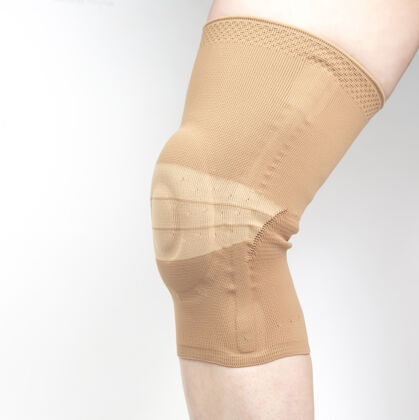 手术用于在白色背景上固定人腿受伤膝盖的绷带关节炎康复背带