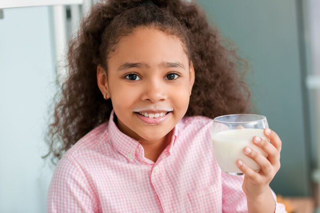 牛奶厨房里有牛奶的非洲裔小女孩有机产品乳糖