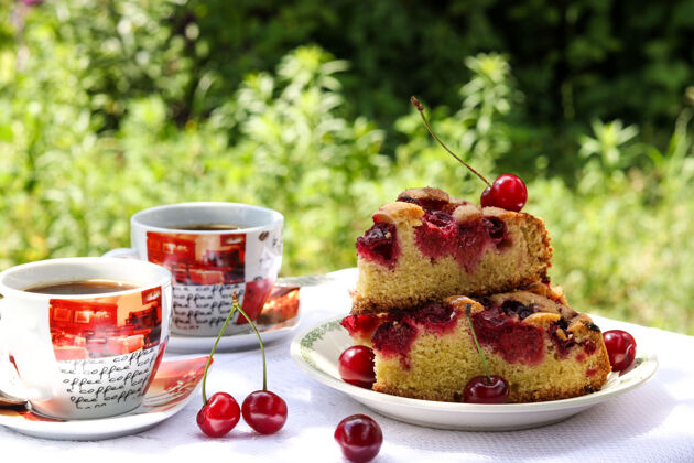 浆果户外桌子上摆着一块樱桃馅饼和两杯咖啡 横摄新鲜早餐糕点