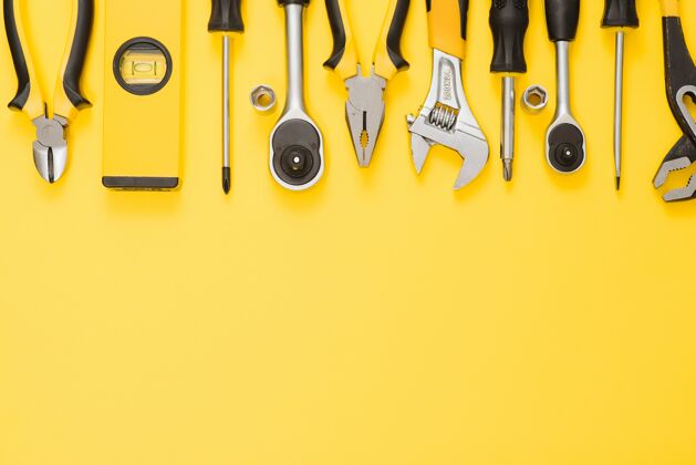 钢铁黄色和黑色的方便工具（起子和螺丝刀）隔离在黄色背景上刀具木工改进