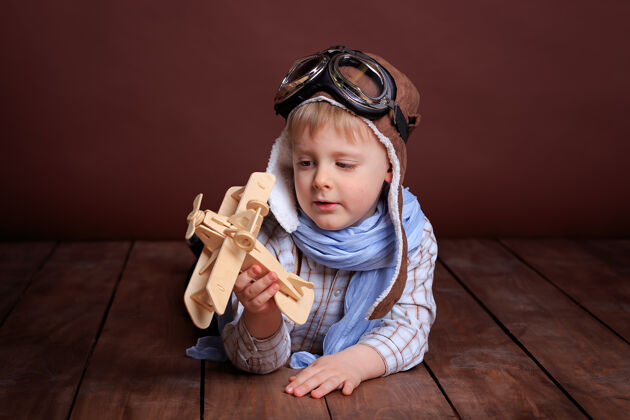 眼镜一个戴着飞行员头盔 戴着蓝色围巾 坐着木飞机的帅哥的画像航空梦想飞行员