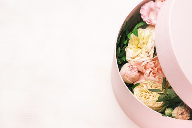 庆祝一个时尚和精致的插花在一个帽子圆盒上的粉红色背景与复制空间装饰婚礼礼物
