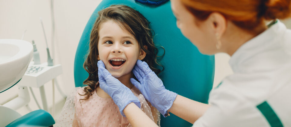 设备一个可爱的小女孩在做牙齿手术前向她的儿科医生展示牙齿的照片牙痛牙齿肖像