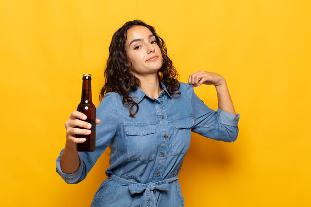 积极年轻的西班牙裔女性看起来傲慢 成功 积极和自豪 指向自我成功漂亮啤酒