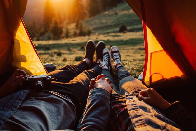 山日落时分 一对年轻夫妇躺在帐篷里准备登山夜晚风格神奇