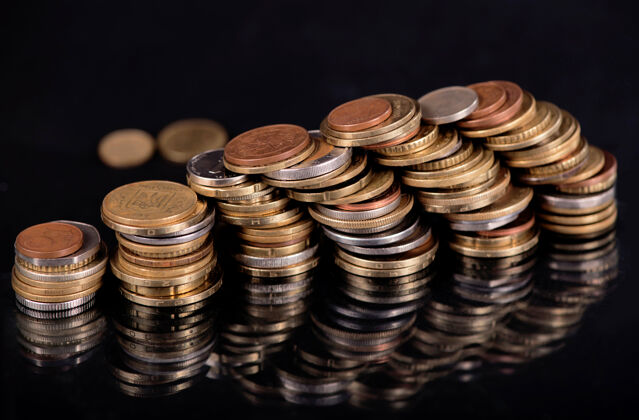 昂贵在黑色背景上堆叠不同国家的硬币铜硬币变化