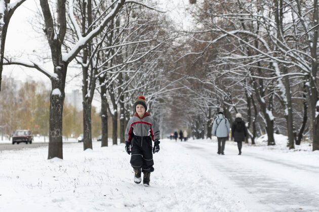 脸孩子在冬天的雪地里散步小公园男孩在散步假日霜冻户外