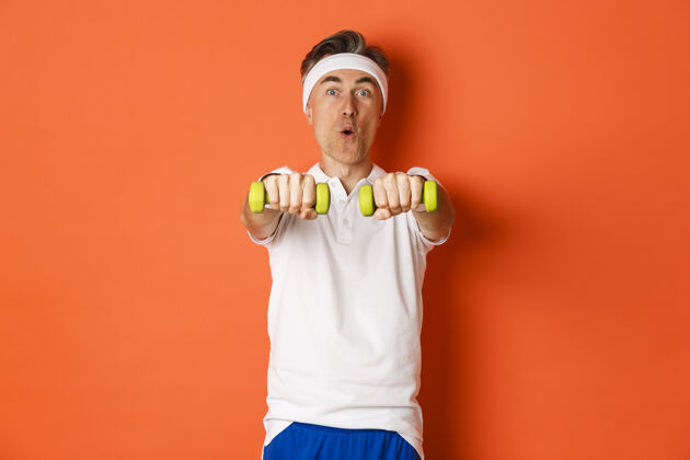 私人教练活跃的中年健身者的画像 用哑铃做运动男哑铃人
