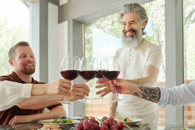 生活方式上图是快乐的老年父母和他们的大孩子在家庭晚餐时碰杯的情景酒桌子庆祝祝酒词