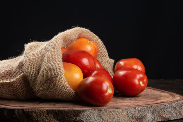 五颜六色成熟的红番茄放在木头上 配上黑色的桌子膳食美味配料