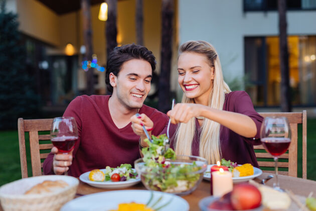 休息餐厅晚餐快乐的夫妇坐在一起 在餐厅 而服务沙拉给对方男人交流关系