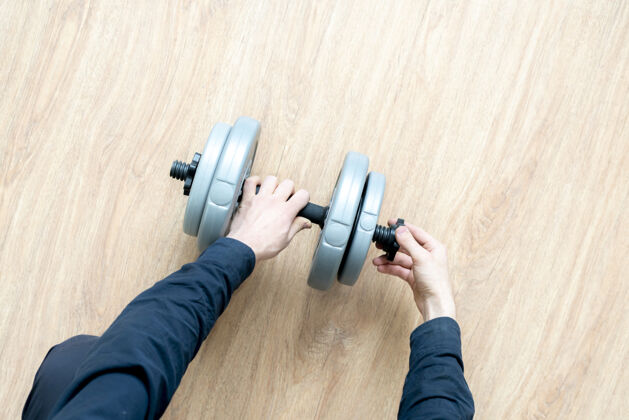 肌肉做运动的人 把一个杠铃哑铃上的weght光盘健身健身房训练