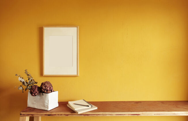 最小木制相框模型旧木架上一堆书上的花盆黄色墙面上的构图室内树叶空