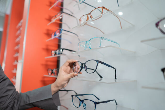 验光师在眼科诊所 一个女人的手拿着一副粘在窗户上的眼镜眼镜展示保护