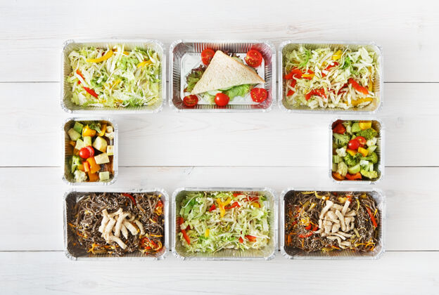 容器提供健康食品 每日定量配给将天然有机食品放在铝箔盒框架内带走俯视图 平放 白色木材处有复印空间健康顶视图晚餐