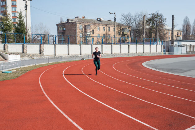 锻炼一个女人在体育场的跑道上跑步夏季健身锻炼跑步 运动 健康积极的生活方式运动草地黑