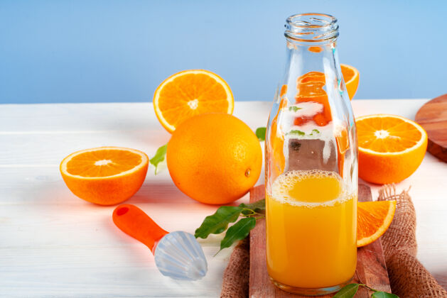 热带桌上摆着一瓶橙汁和新鲜橙子有机玻璃饮食