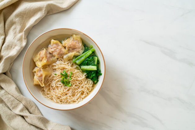 膳食鸡蛋面配猪肉馄饨汤或猪肉饺子汤和蔬菜-亚洲风味蔬菜美食筷子